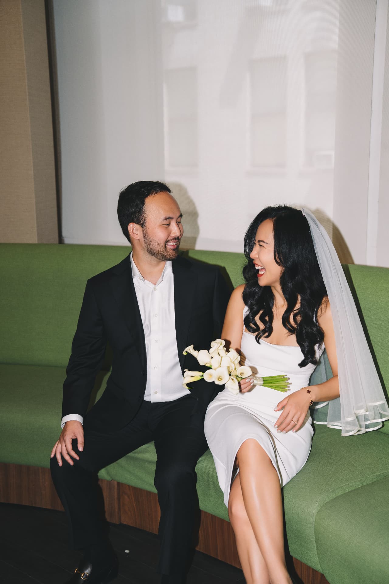 Coco and Alex laughing together on their wedding day